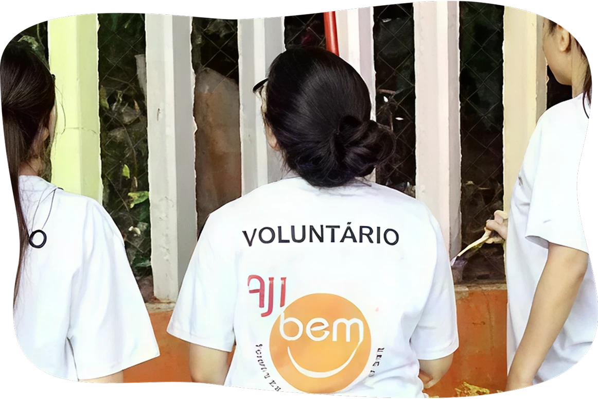 Voluntários de costas mostrando a camiseta do projeto